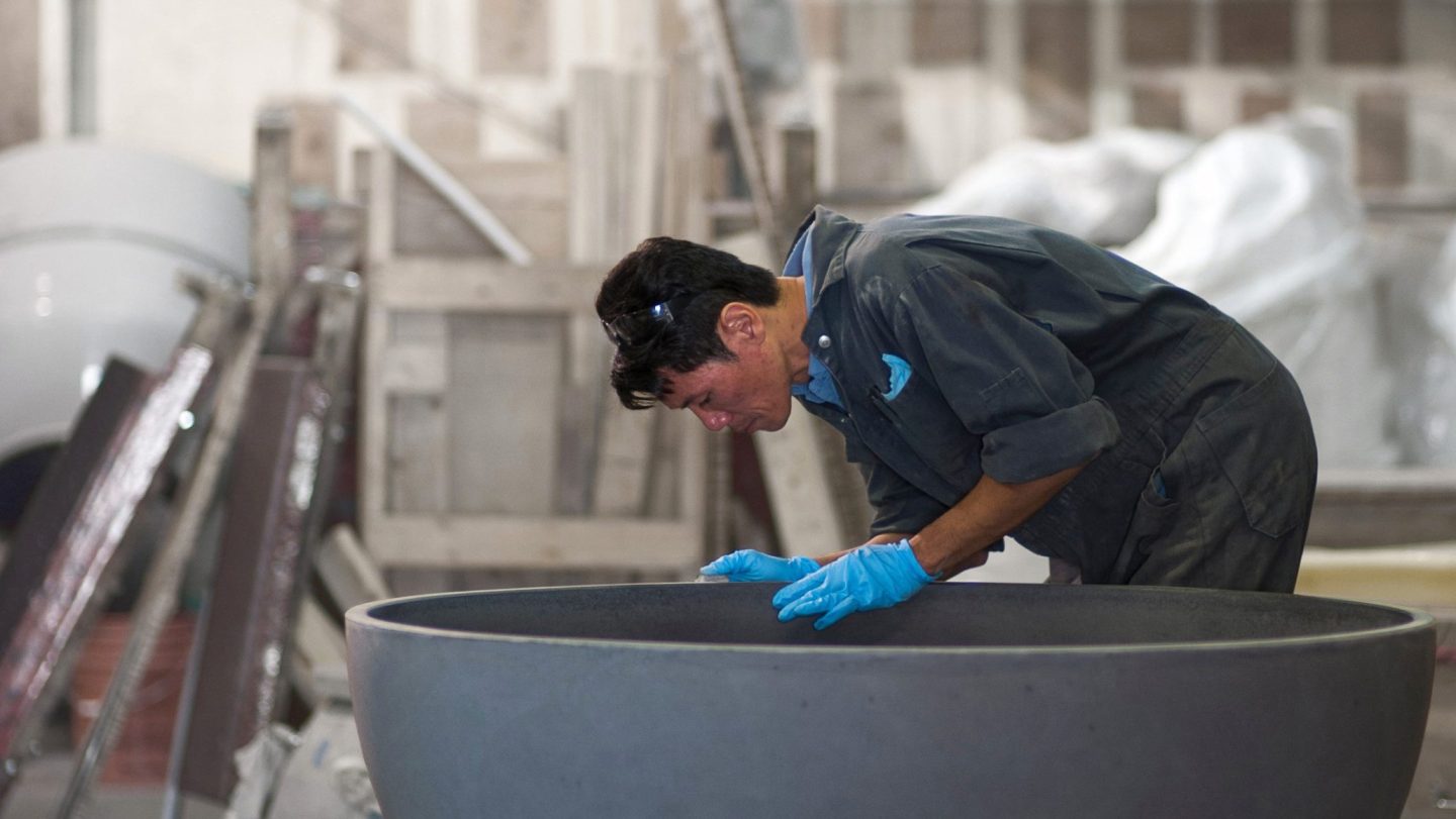 Solus Decor team inspecting a concrete fire pit at the Vancouver manufacturing facility